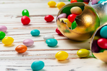Easter concept.  Eggs and colored sweets on table close up