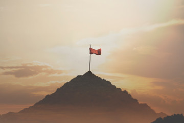 flag planted on top of a mountain, success concept