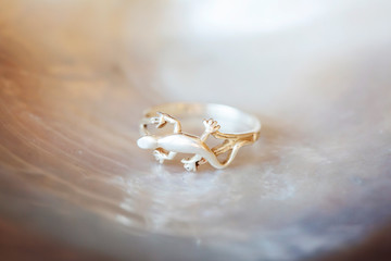 Sterling silver ring in shape of lizard on white shell background
