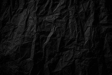 Dark black crumpled paper close up texture background