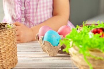 Little girl's hand holding painted Easter egg. Close up shot