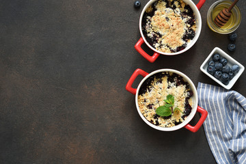 Crumble with berries, nuts and oatmeal on a concrete background. View from above.