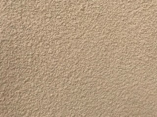 An Exterior textured painted outside of the highrise building with beige color and looking like...