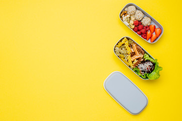 Plastic lunch box with healthy food on yellow background with copy space