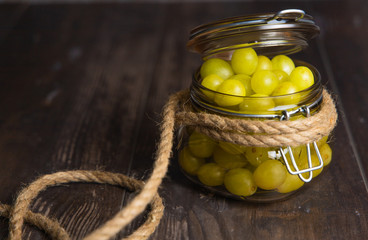 Jar of fresh grapes with handmade rope on an old basis