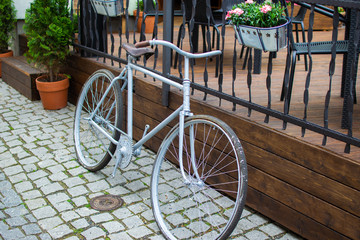 White classic comfort bike parked in a fence in the old town of Loket, Czech Republic