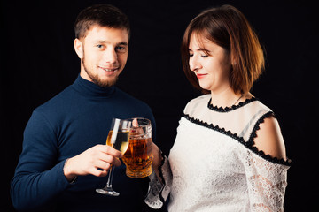 A man and a woman on a black background, a woman drinking beer and a man drinking champagne is a stereotypical activity
