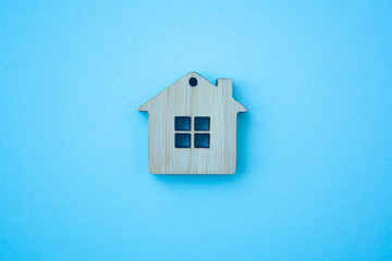 House, insurance and mortgage, buing and rent concept. Small wooden house toy on blue background top view
