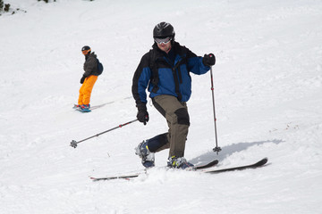Fototapeta na wymiar A man goes skiing on a snow-covered ski track. Ski resort. A man on snowboard. Winter sport.