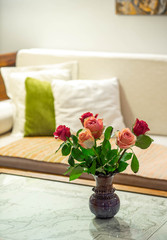 Roses in the vase on the marble table. Beautiful flowers in interior. Close-up.