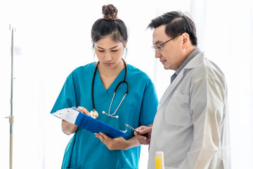 Medical professionals Asian young woman holding document and conversation about patient with senior doctor man.