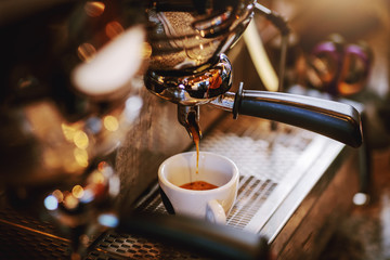 Close up of espresso machine with cup.