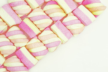 Background from colorful zephyr. Yellow and pink small candy marshmallow. Greeting card for Birthday, anniversary, holiday. Selective focus.