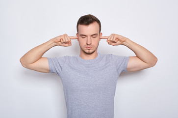 Fototapeta premium The young man closed his eyes and ears, does not want to listen to anything.