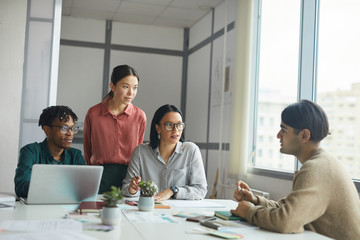 Young business people listening to their partner while he reporting his presentation during meeting at office