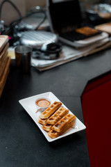 homemade waffles stick with maple syrup in mini cafe