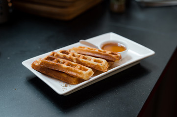 homemade waffles stick with maple syrup in mini cafe