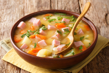 Serving of split pea soup with ham close-up in a bowl. horizontal