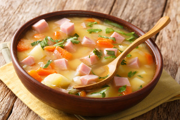 Organic vegetable soup with peas and ham close-up in a bowl. horizontal