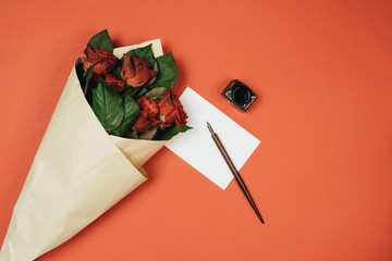 Beautiful bouquet with red roses, blank card and ink pen for card. Celebration woman day. Gift
