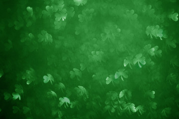 Fototapeta na wymiar Clover shaped bokeh. St.Patrick 's Day. Blurred abstract background. Green shamrock. Real photo