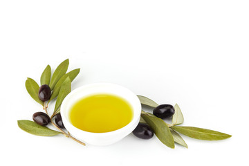 bowl of fresh olive oil and olive branches on white background