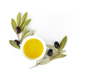 bowl of fresh olive oil and olive branches on white background