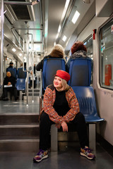 full Blonde sitting in a subway car or funicular