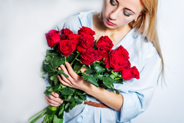 Blond woman hold red roses in hands