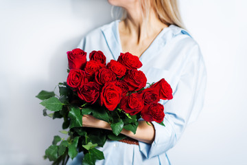 Blond woman hold red roses in hands