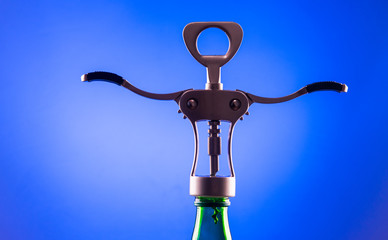 Corkscrew for opening bottles of wine on a blue background in the neck of the bottle