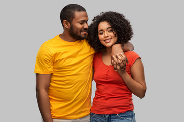 Naklejka premium relationships and people concept - happy african american couple hugging over grey background