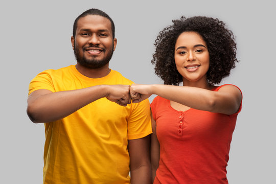 relationships and people concept - happy african american couple making fist bump gesture over grey background - Powered by Adobe