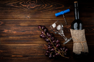 Red wine and grape on dark wooden background.