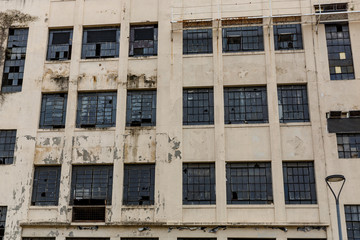 The facade of an abandoned building. Broken windows and peeling paint.