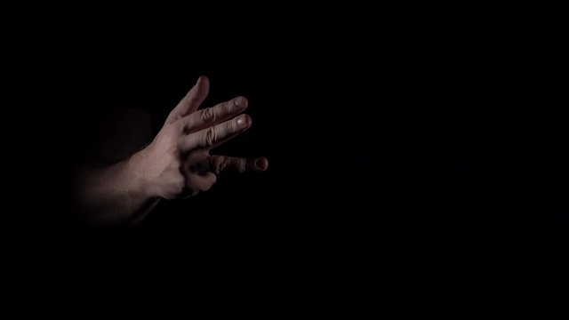 Caucasian male hand demonstrates counting on fingers from one to five on black background isolated 4K