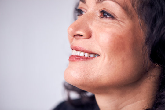 Close Up On Face Of Smiling Mature Woman In Studio