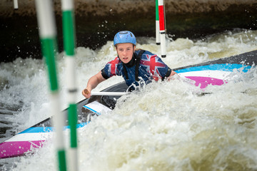 Close up action of a GB Canoe Slalom Athlete negotiating the poles of slalom gates on white water...