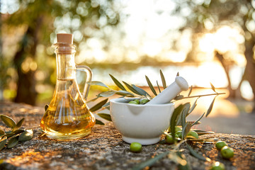 Olive oil and olive berries with leaves outdoor