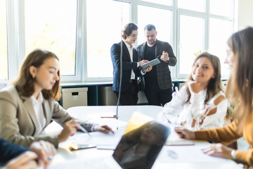 Team of young business professionals using technology in an informal meeting engaged on architect design. . Concept of successful startup