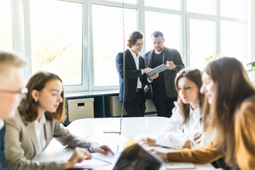 Team of young business professionals using technology in an informal meeting engaged on architect design. . Concept of successful startup
