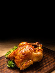 Roasted whole chicken on wooden cutting board