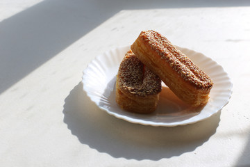 Piece of palmiers pastry, on the plate isolated on white background. With honey