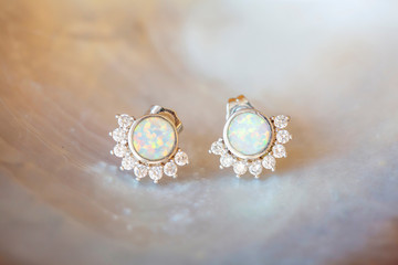 White opal and zircone sterling silver earrings on white shell background