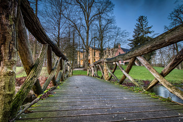 A wooden bridge through a forest leading to a colored hotel in Deventer, the Netherlands