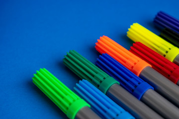 Multi-colored felt-tip pens. Markers are isolated on a colored background.