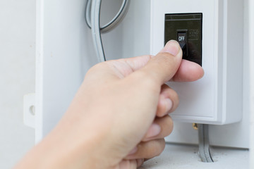 Naklejka premium Hand is holding the old breaker switch