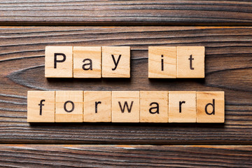 Pay It Forward word written on wood block. Pay It Forward text on wooden table for your desing, concept