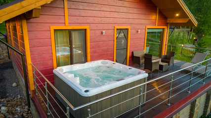 Wooden cottage with hot tub. The hot tub is located on the terrace of the cottage. House with...