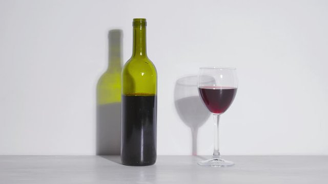 Conceptual shot, a bottle of wine and a glass on a white background